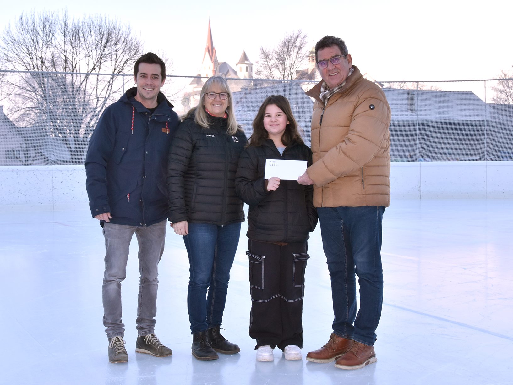(v.l.) Andreas Wally von der Marktgemeinde Rankweil, Conny Ketterer vom Eislaufplatz Gastra, Gewinnerin Sabina Szabo und Gemeinderat Helmut Jenny bei der Übergabe des Gutscheins