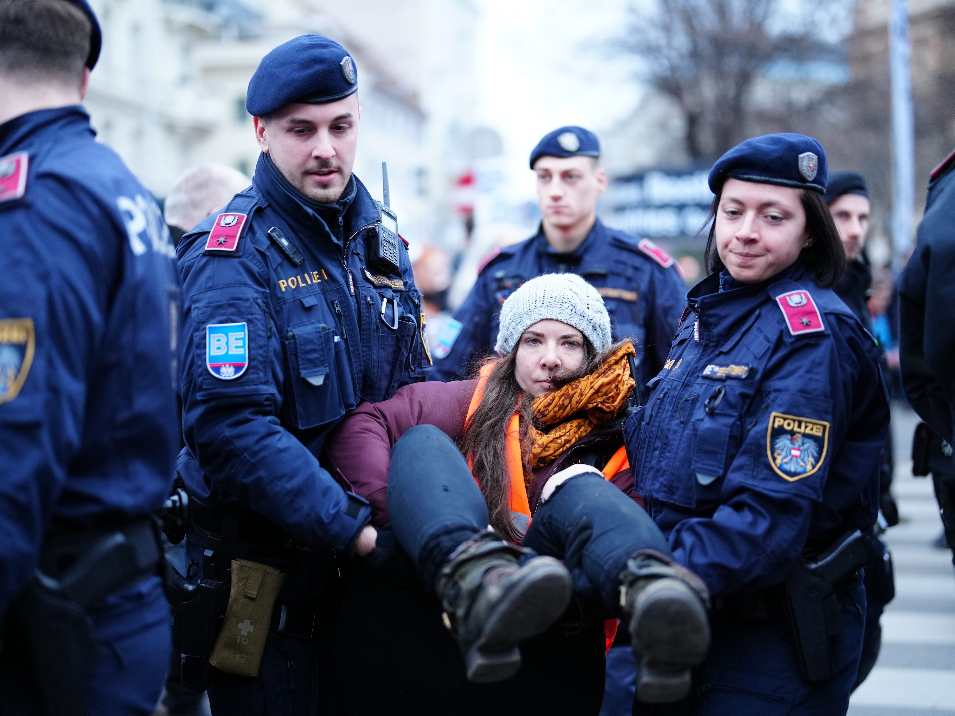 Eine Aktivistin wird von der Polizei weggetragen.