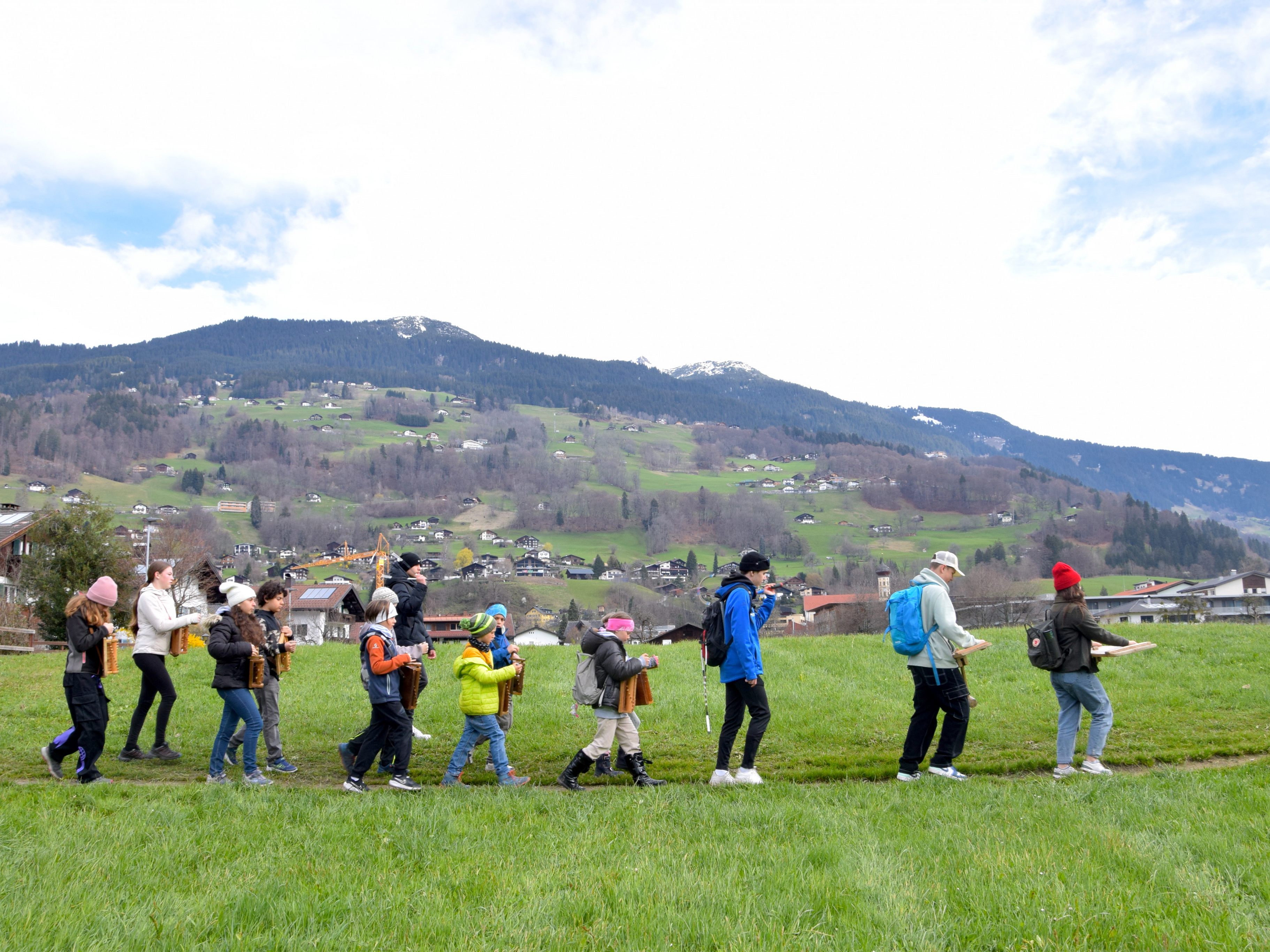 Schrunser Rätschner unterwegs in ihrer Heimatgemeinde, zwischen Feldweg und Wagenweg