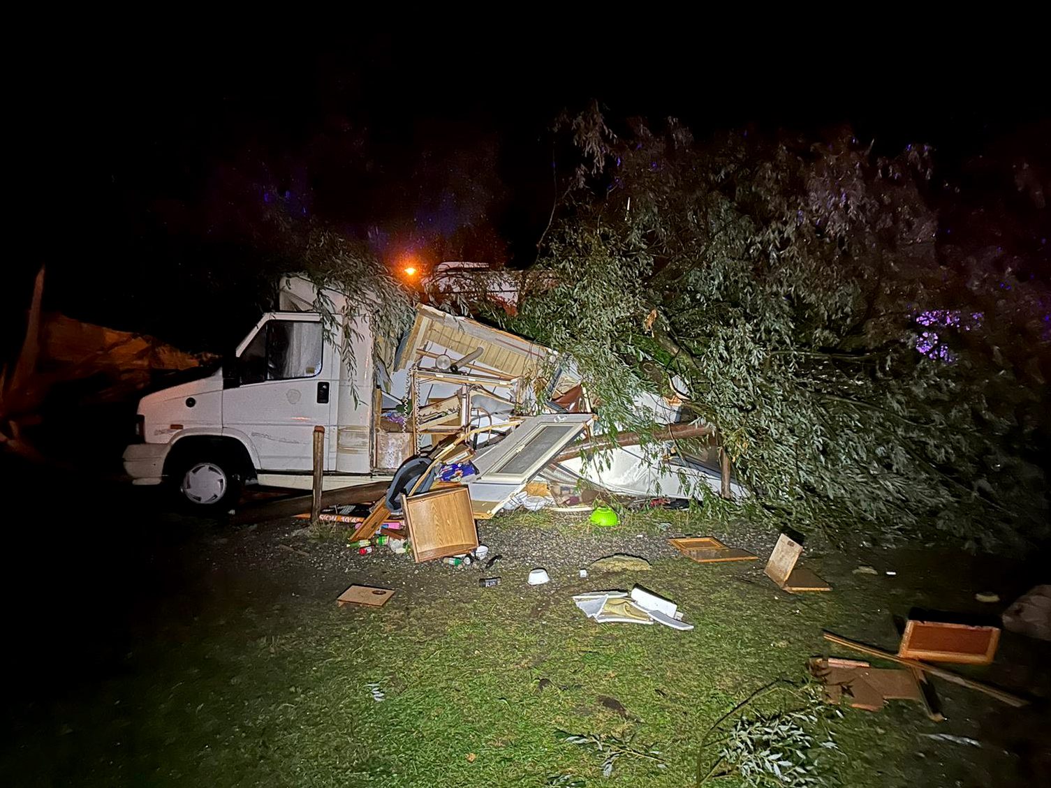 Ein umgestürzter Baum liegt auf einem Wohnmobil auf einem Campingplatz