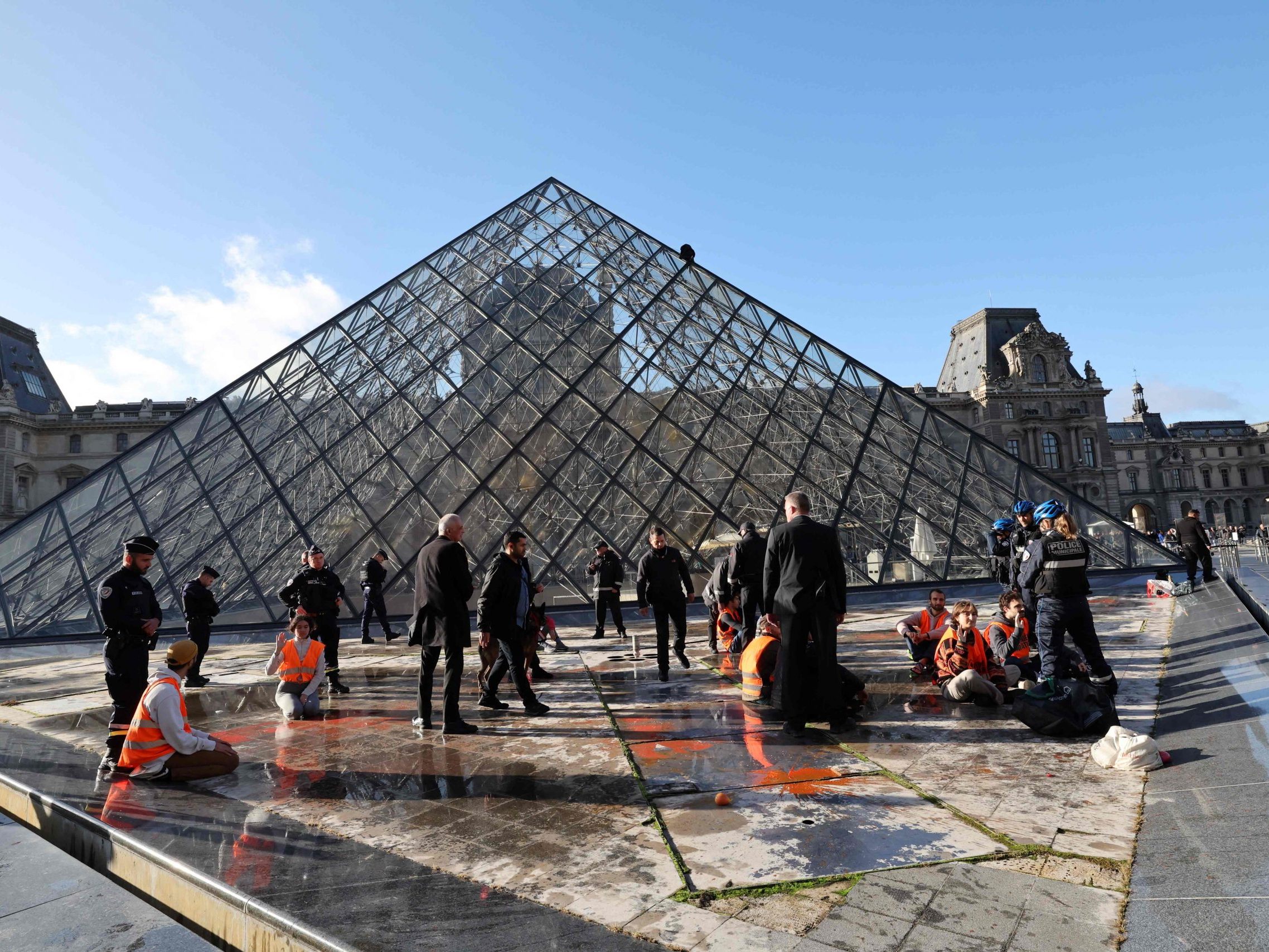 Orange Farbattacke auf die Louvre-Pyramide.