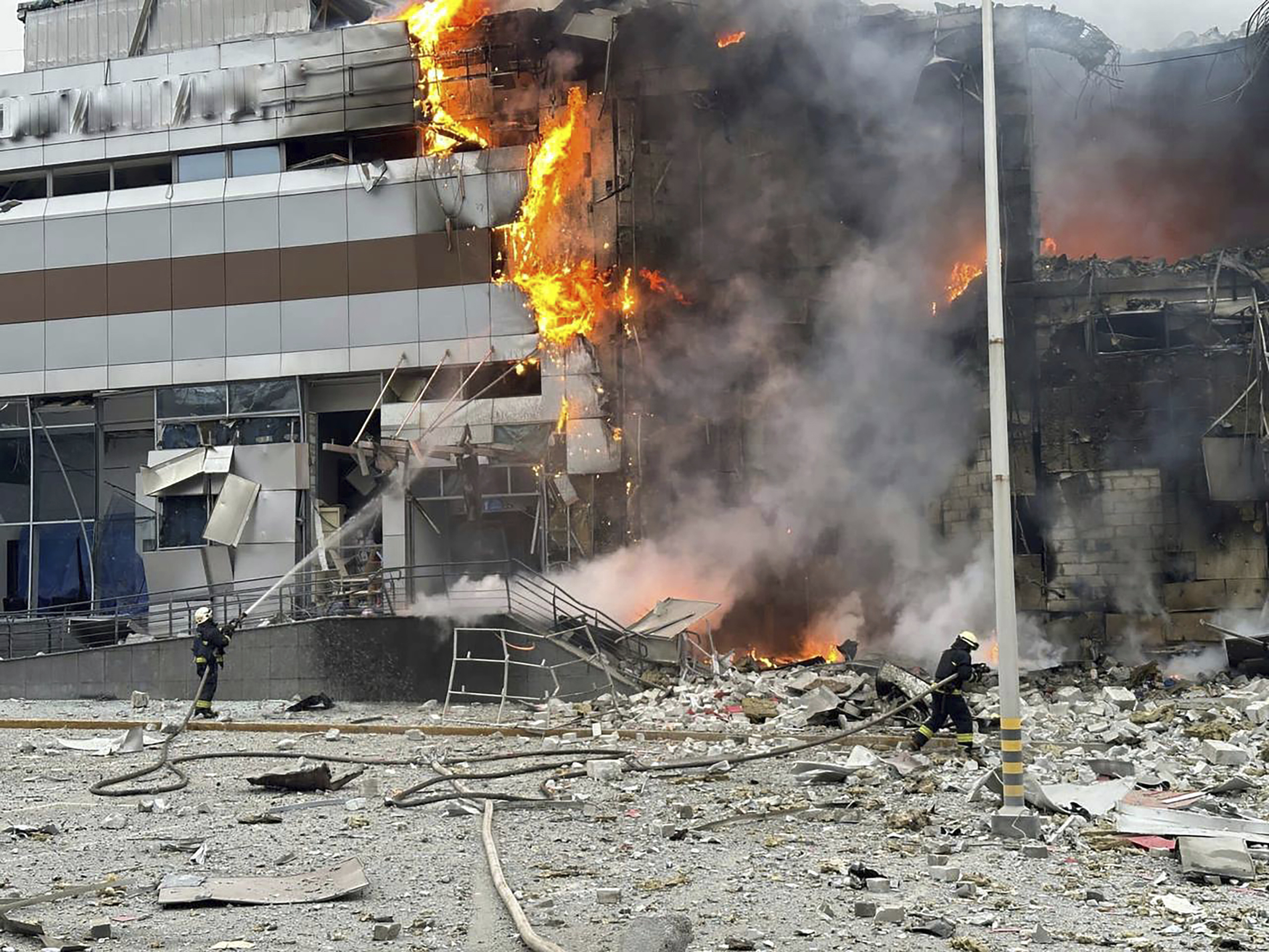 Feuerwehrleute versuchen nach der Attacke in Kiew am Freitag ein getroffenes Gebäude zu löschen.