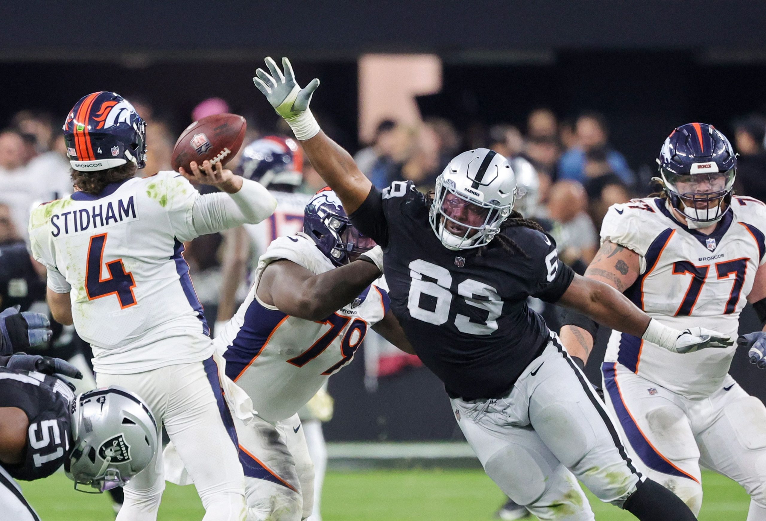 Quarterback Jarrett Stidham #4 der Denver Broncos wirft eine Interception unter dem Druck von Defensive Tackle Adam Butler #69 der Las Vegas Raiders gegen Ende des vierten Viertels ihres Spiels im Allegiant Stadium am 7. Januar 2024 in Las Vegas, Nevada Quarterback Jarrett Stidham #4 der Denver Broncos wirft eine Interception unter dem Druck von Defensive Tackle Adam Butler #69 der Las Vegas Raiders gegen Ende des vierten Viertels ihres Spiels im Allegiant Stadium am 7. Januar 2024 in Las Vegas, Nevada