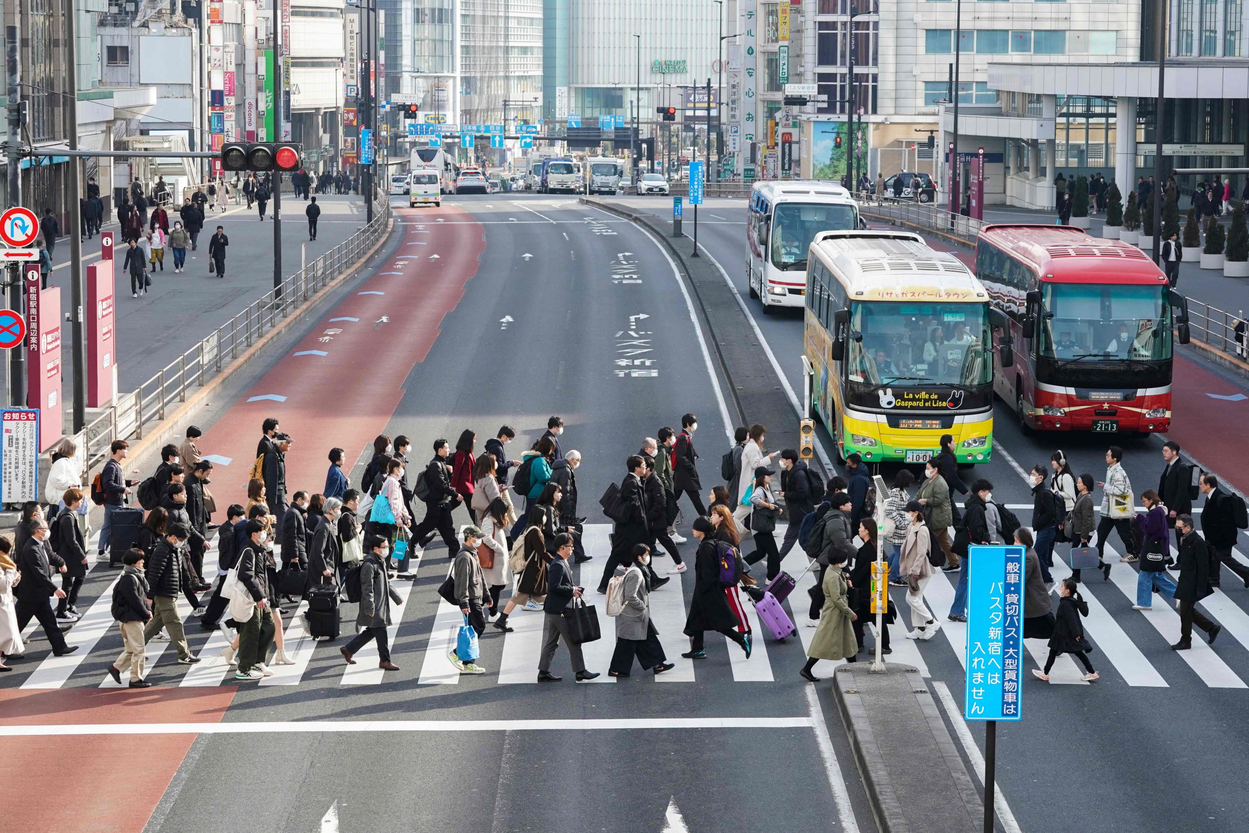 Menschen, die morgens zur Arbeit pendeln, überqueren einen Fußgängerübergang in Tokio am 15. Februar 2024.