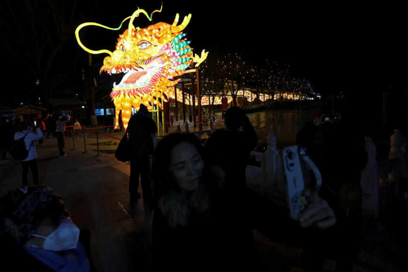 Menschen fotografieren eine Dracheninstallation vor dem chinesischen Neujahr in Peking, China, am 7. Februar 2024.