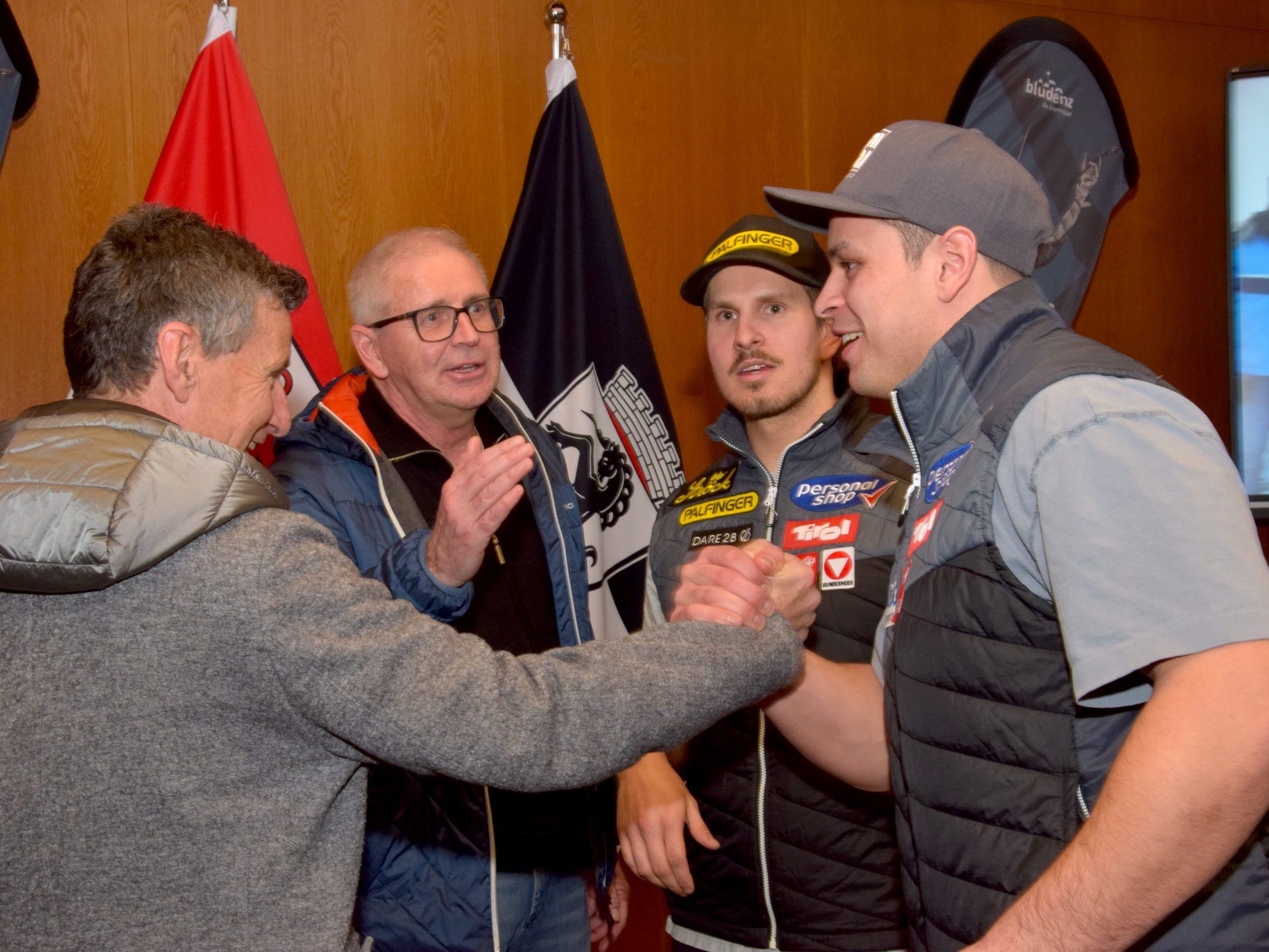 Die beiden Fußball-Legenden Günter Berchtold (l.) und Harald Schuster gratulieren Jonas Müller (r.) und Thomas Steu.