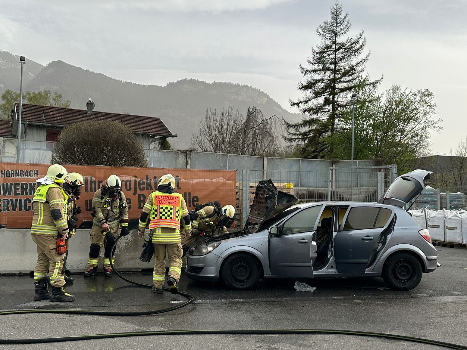 Die Feuerwehr am brennenden Auto.