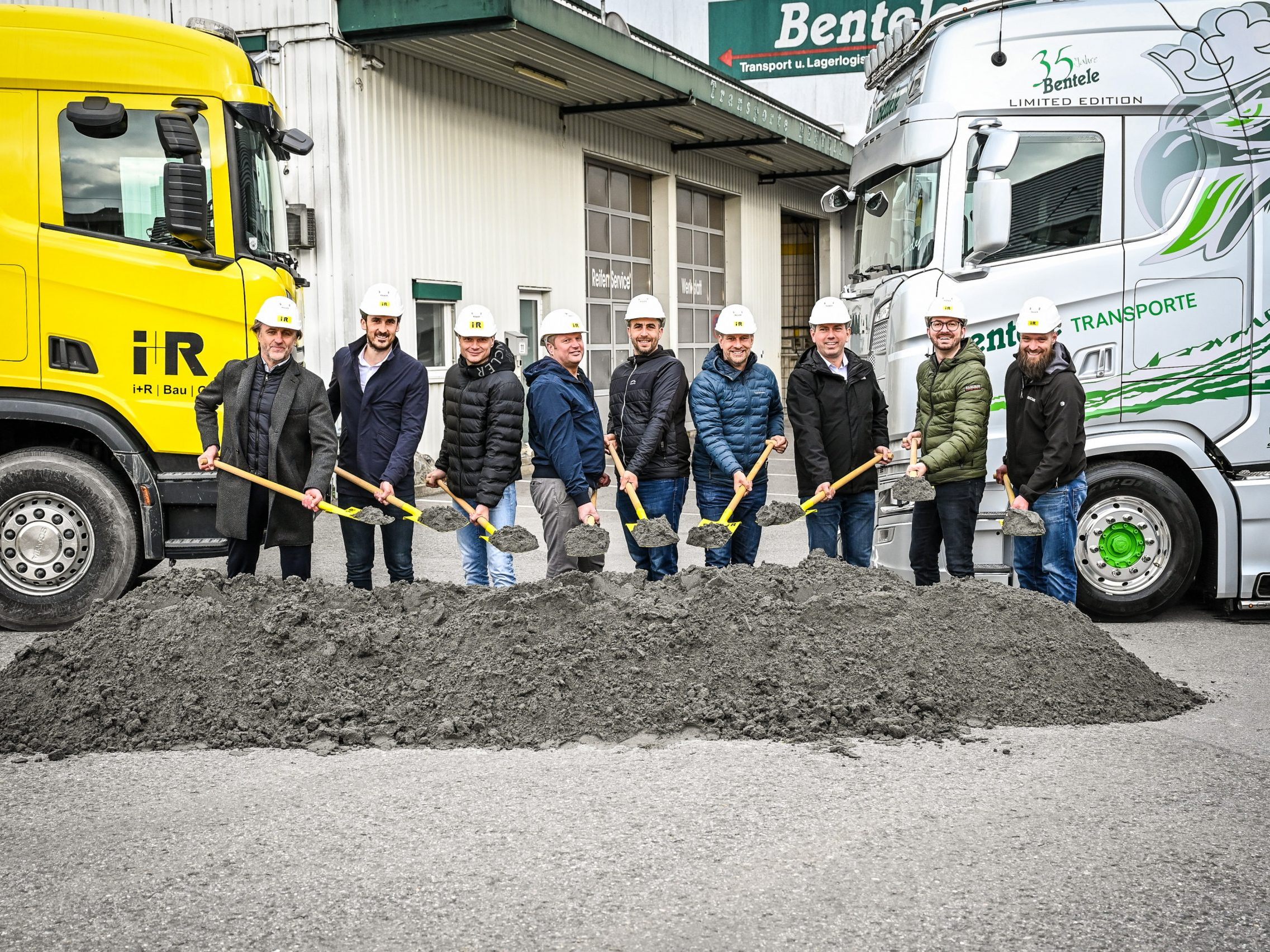Spatenstich zur Sanierung und Erweiterung von Bentele Transporte in Hohenems: Martin Epp (Geschäftsbereichsleiter i+R Bestandsbau), Mario Bischof (Geschäftsführer i+R Industrie- & Gewerbebau), Jürgen Bentele (Eigentümer und Geschäftsführer Bentele Transporte), Arno Bentele (Eigentümer und Geschäftsführer Bentele Transporte), Patrick Kalin (Patrick Kalin Bauplan GmbH), Dieter Egger (Bürgermeister Hohenems), Markus Klien (Stadtrat Hohenems), Aleks Jeremic (Projektleiter i+R), Jörg Cramer (Bauleiter i+R). Spatenstich zur Sanierung und Erweiterung von Bentele Transporte in Hohenems: Martin Epp (Geschäftsbereichsleiter i+R Bestandsbau), Mario Bischof (Geschäftsführer i+R Industrie- & Gewerbebau), Jürgen Bentele (Eigentümer und Geschäftsführer Bentele Transporte), Arno Bentele (Eigentümer und Geschäftsführer Bentele Transporte), Patrick Kalin (Patrick Kalin Bauplan GmbH), Dieter Egger (Bürgermeister Hohenems), Markus Klien (Stadtrat Hohenems), Aleks Jeremic (Projektleiter i+R), Jörg Cramer (Bauleiter i+R).