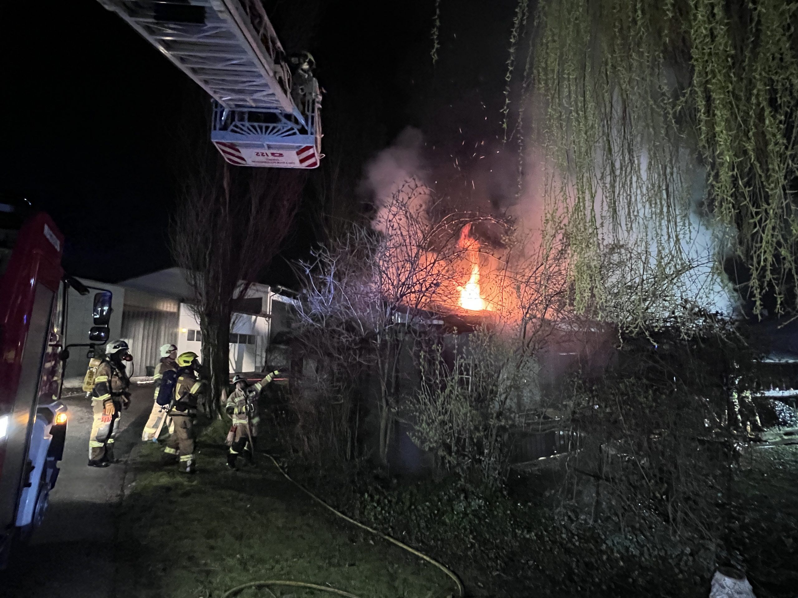 Die Flammen schlagen aus dem Dach des Hauses.