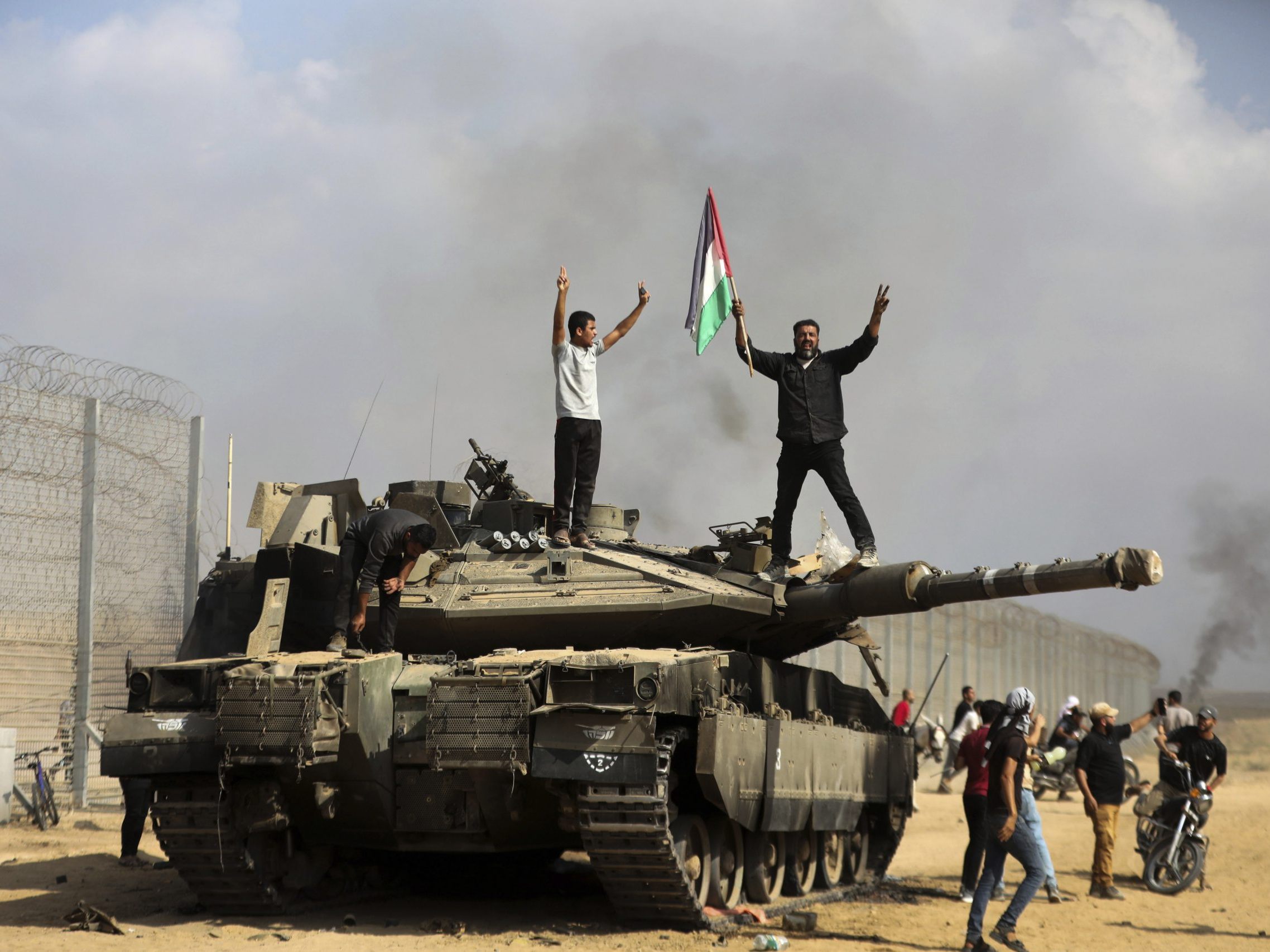 Palästinenser feiern einen zerstörten israelischen Panzer bei Khan Younis (17. März 2024). Palästinenser feiern einen zerstörten israelischen Panzer bei Khan Younis (17. März 2024).
