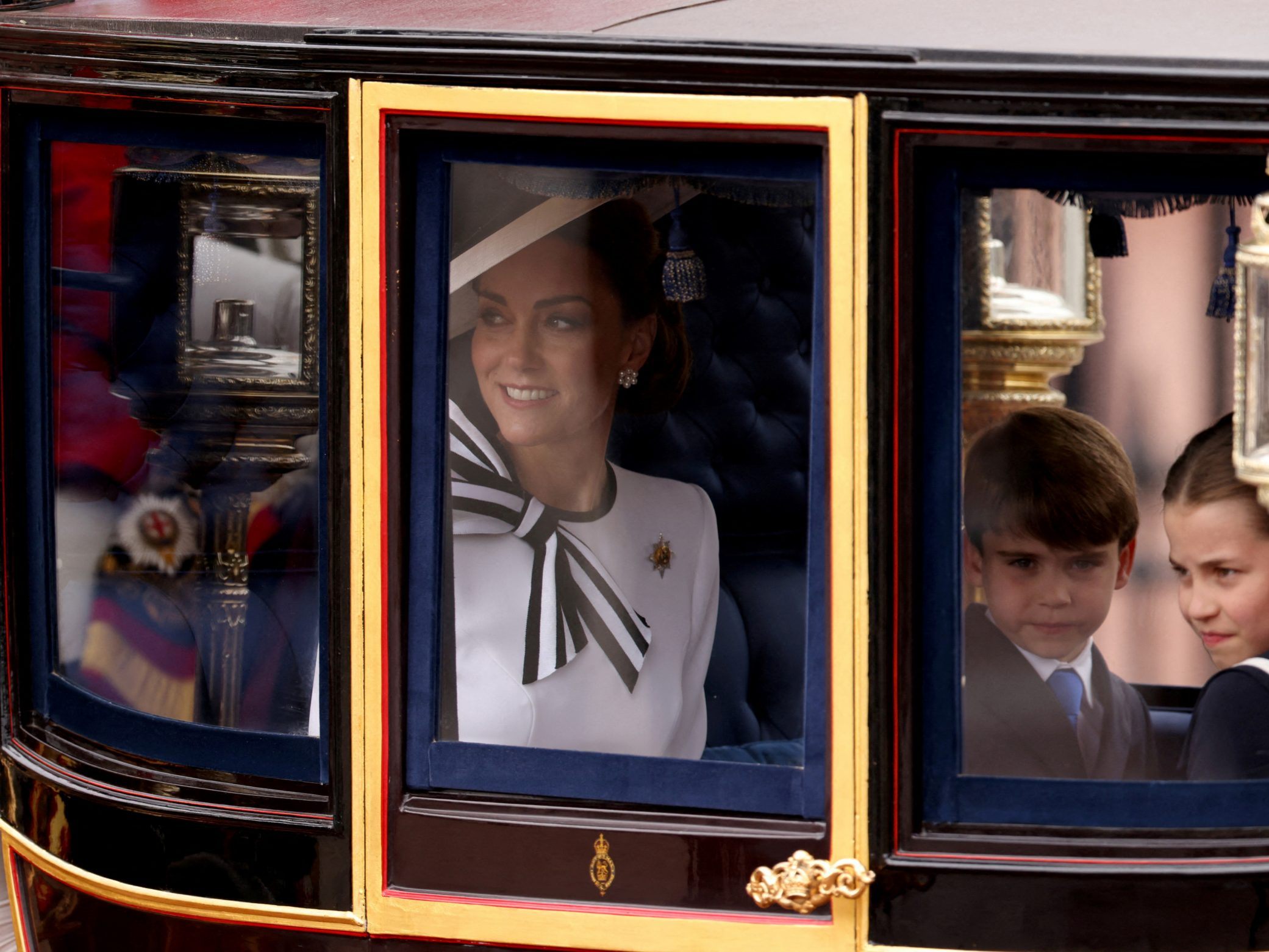 Prinzessin Kate im weißen Dress und mit passendem Hut.