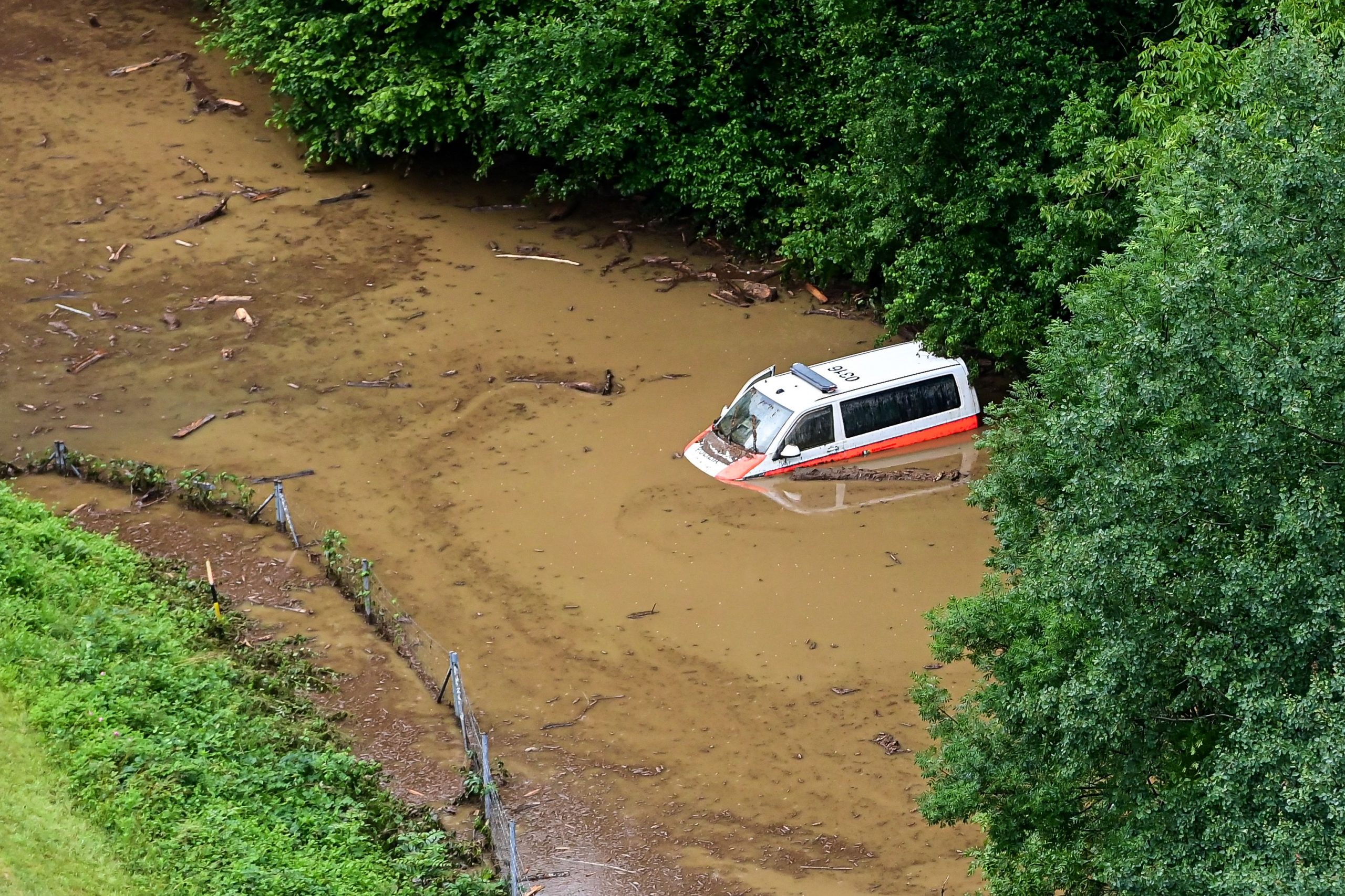 Dieses Luftbild zeigt einen Polizeiwagen im Wasser im Kanton Graubünden 