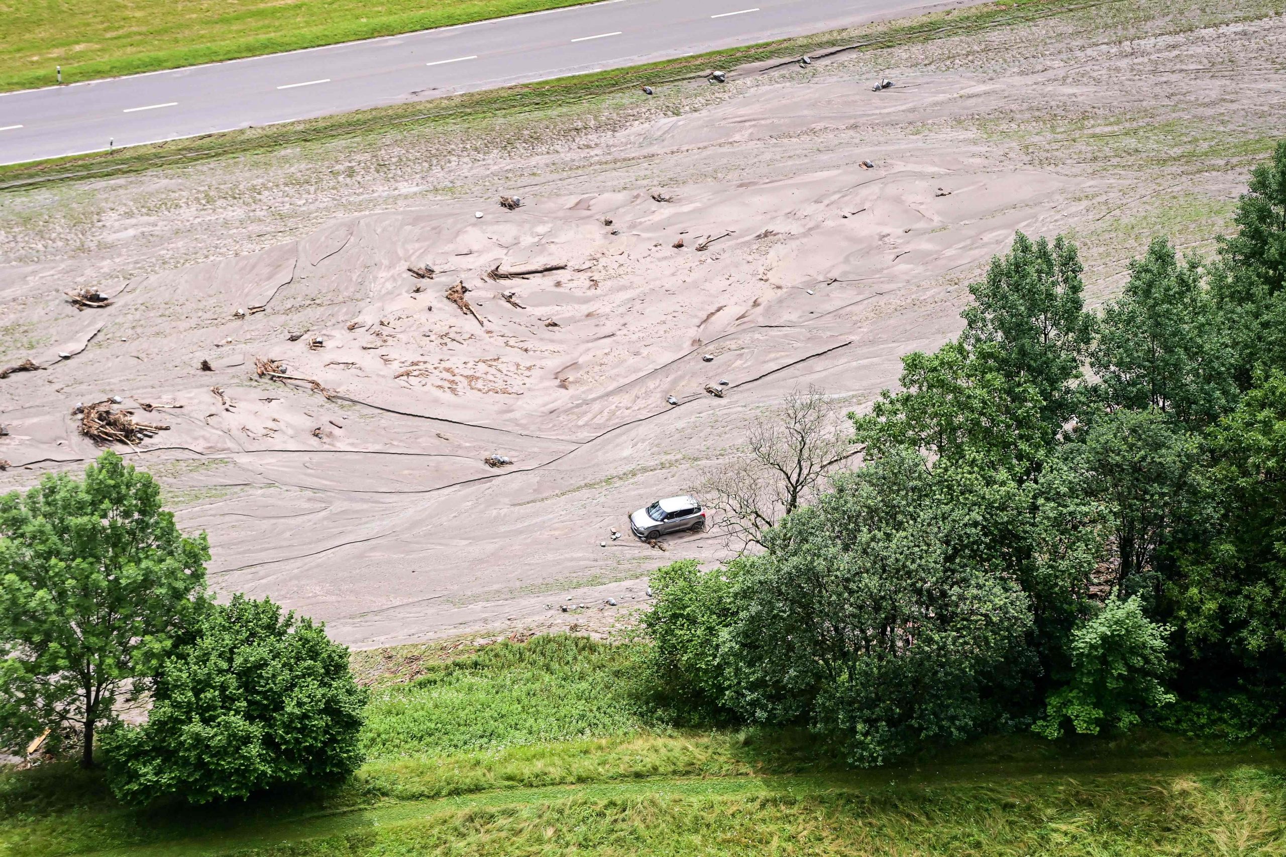 Dieses Luftbild zeigt ein im Schlamm steckendes Auto im Kanton Graubünden in der Schweiz