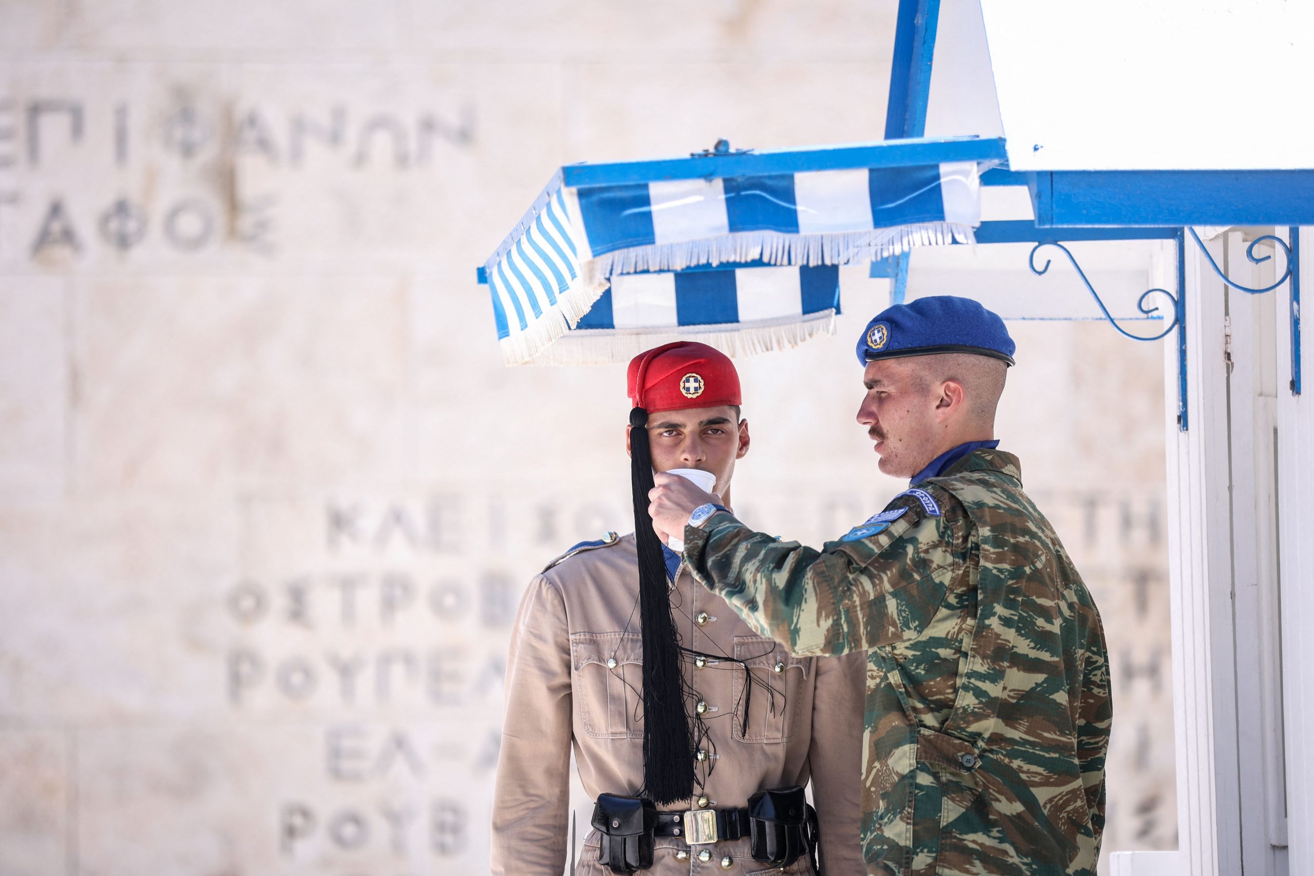 Athen: Ein Beamter gibt einem Mitglied der Präsidialgarde Wasser.