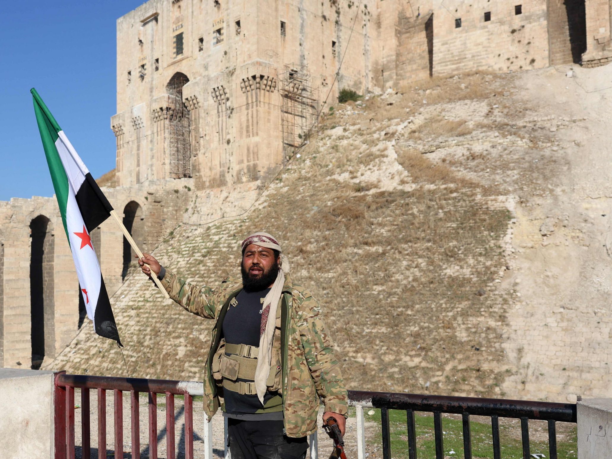 Ein regierungsfeindlicher Kämpfer hisst eine Oppositionsflagge vor der Zitadelle von Aleppo.