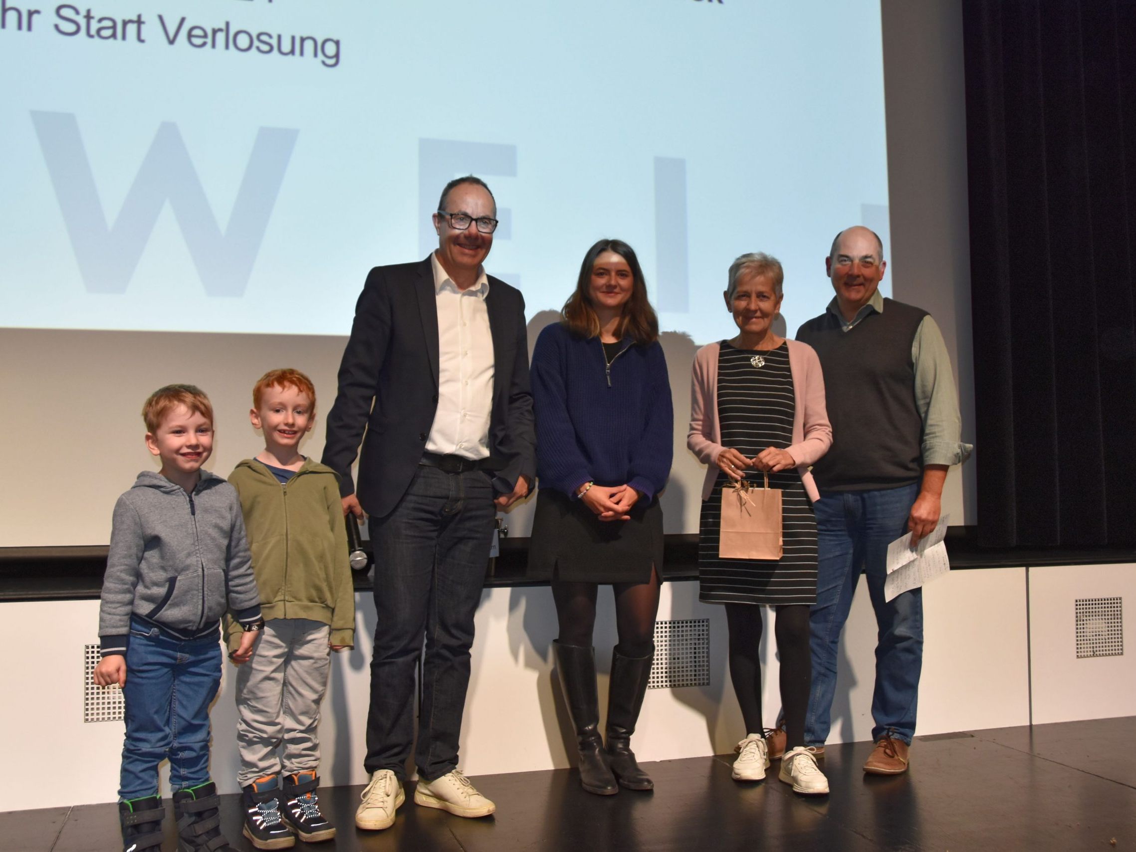 Vize-Bürgermeister Andreas Prenn, Katrin Ehrenbrandtner (MG Rankweil) und GR Alejandro Schwaszta mit der Siegerin des Hauptpreises, Brigitte Künzle sowie den beiden „Glücksfeen“, die den Preis zogen.