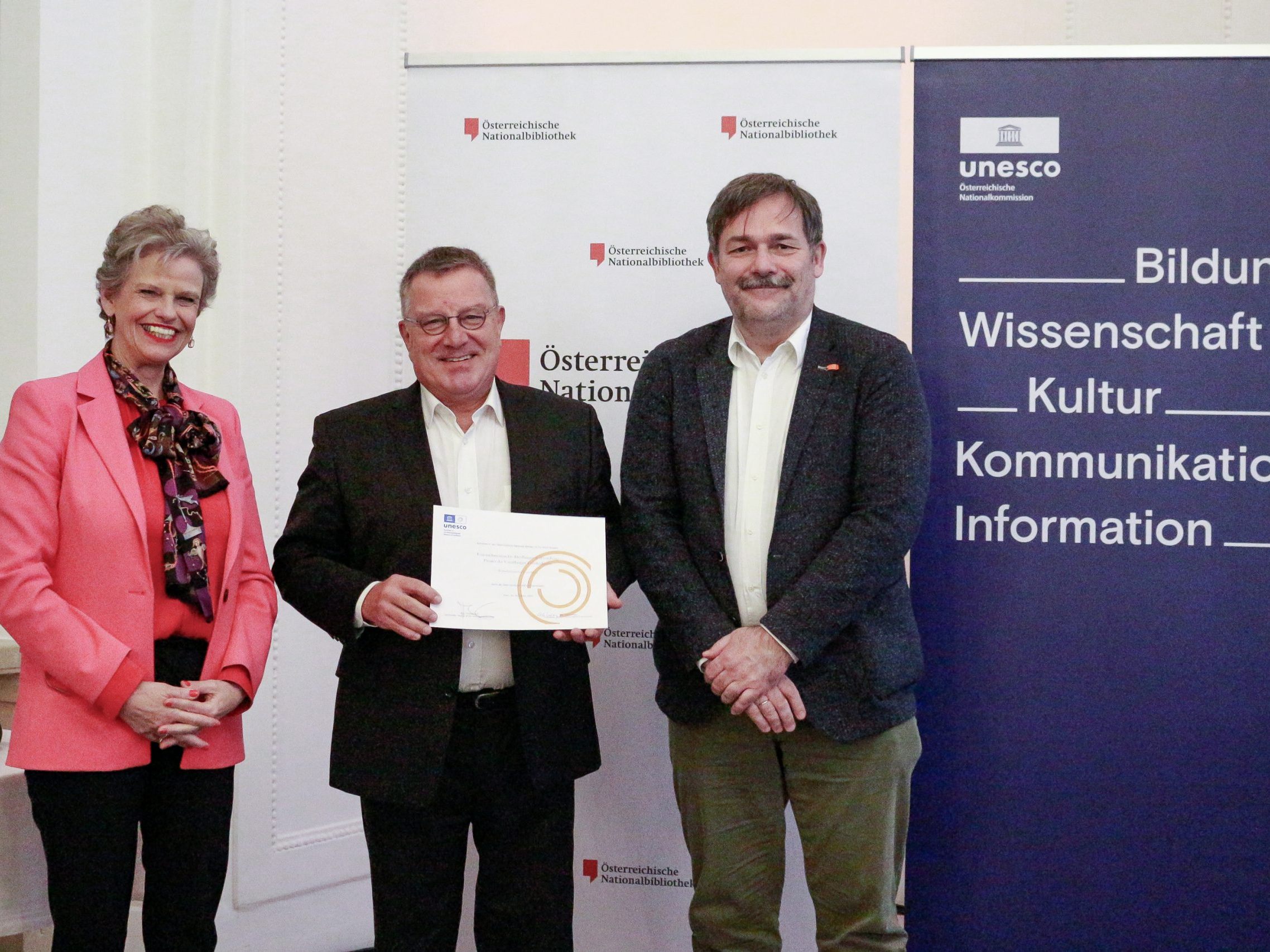 Dr.in Sabine Haag, Präsidentin der Österreichischen UNESCO-Kommission, überreicht die Aufnahmeurkunde an DDr. Arno Fitz, Obmann des Wirtschaftsarchivs Vorarlberg, und dessen Stv. und Kassier Karlheinz Kindler (rechts).