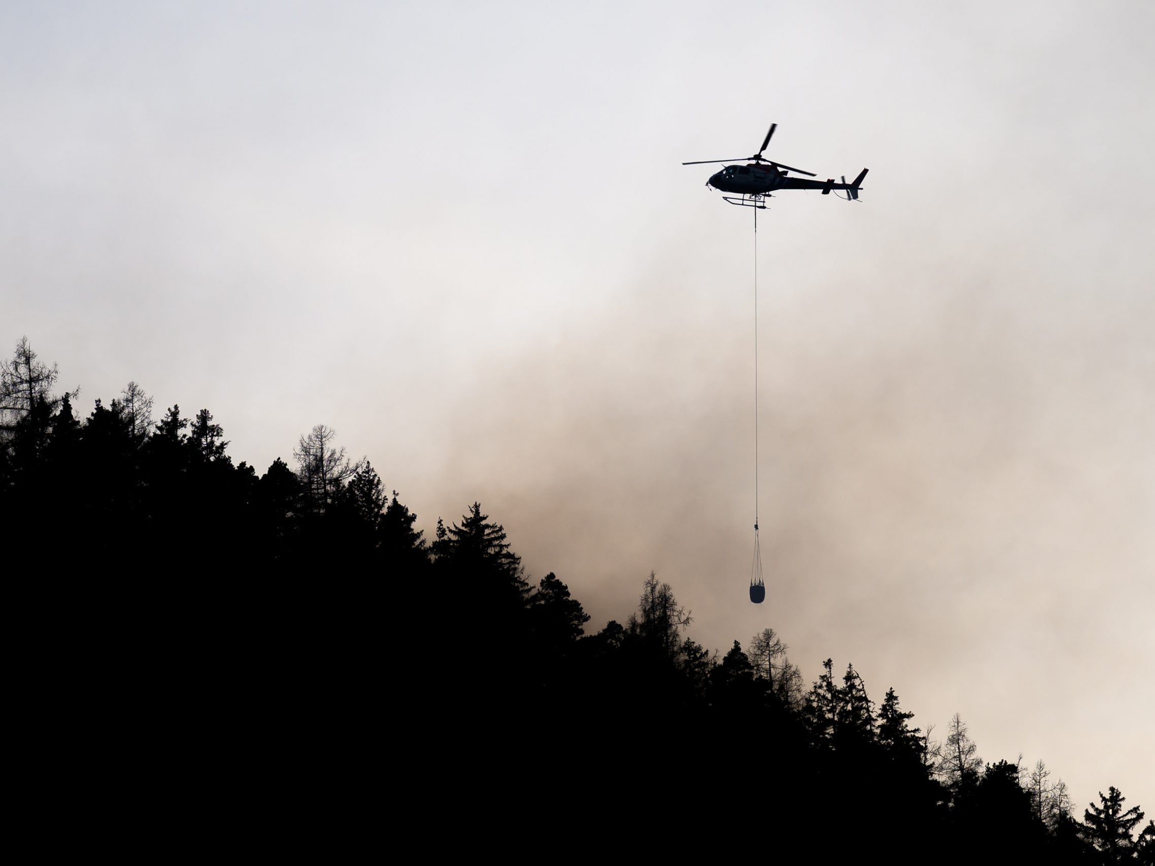 Die Feuerwehrleute werden von Löschhubschraubern unterstützt.