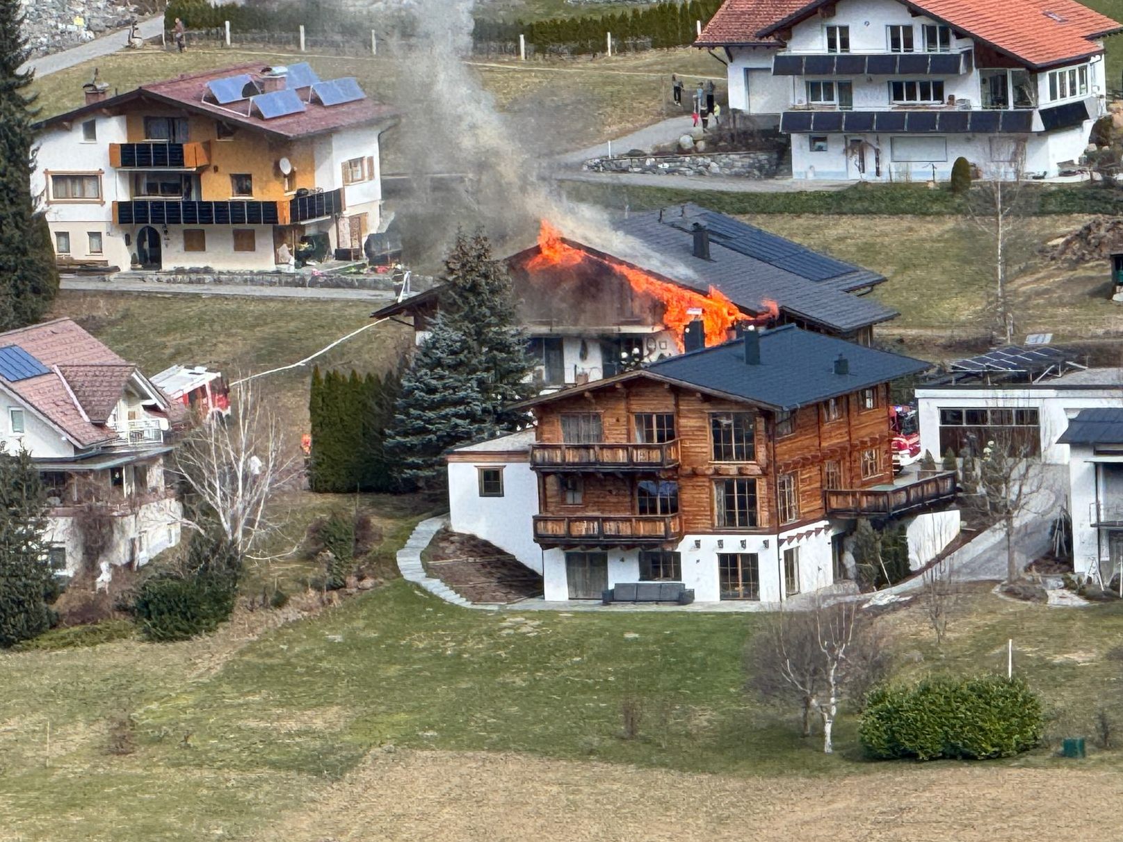 Flammen schlagen aus dem Dach des Gebäudes.