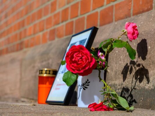 Blumen und Kerzen am Bahnhof Friedland