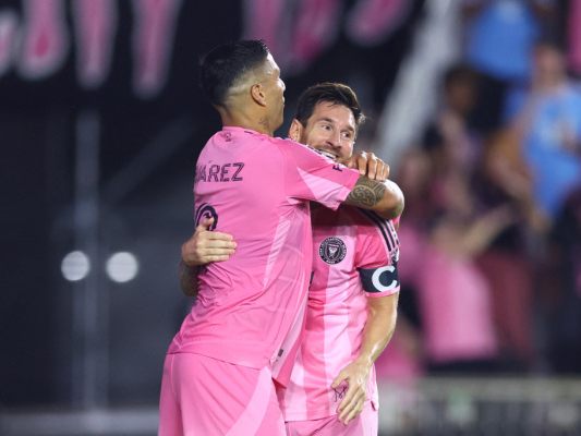 Lionel Messi/r. wird von Luis Suarez geherzt