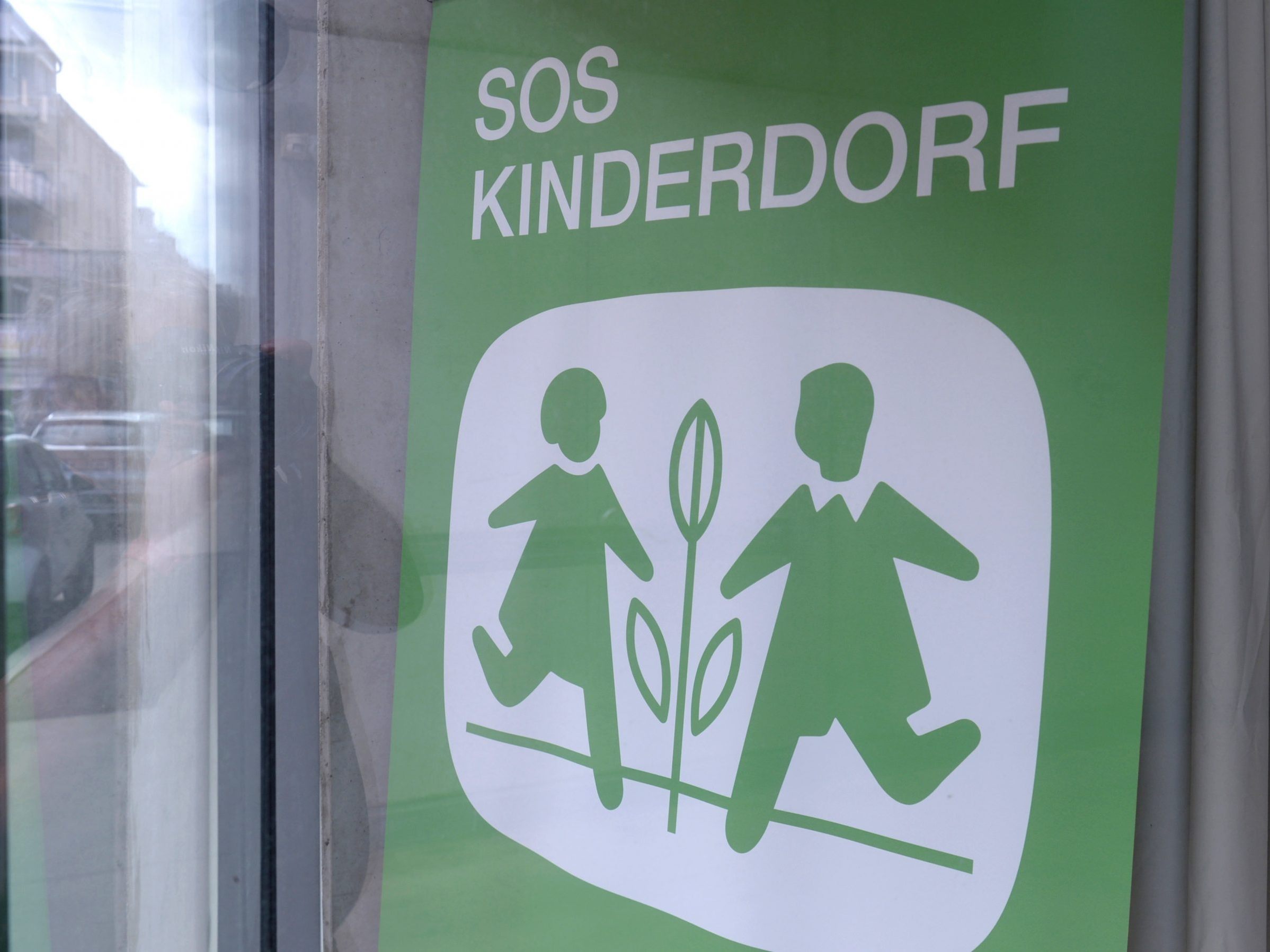 "SOS-KINDERDORF" ist in einem Schaufenster zu lesen.