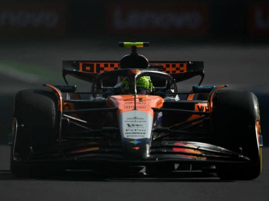 Auf dem Foto sieht man Lando Norris in seinem orange-grauen McLaren-Auto.