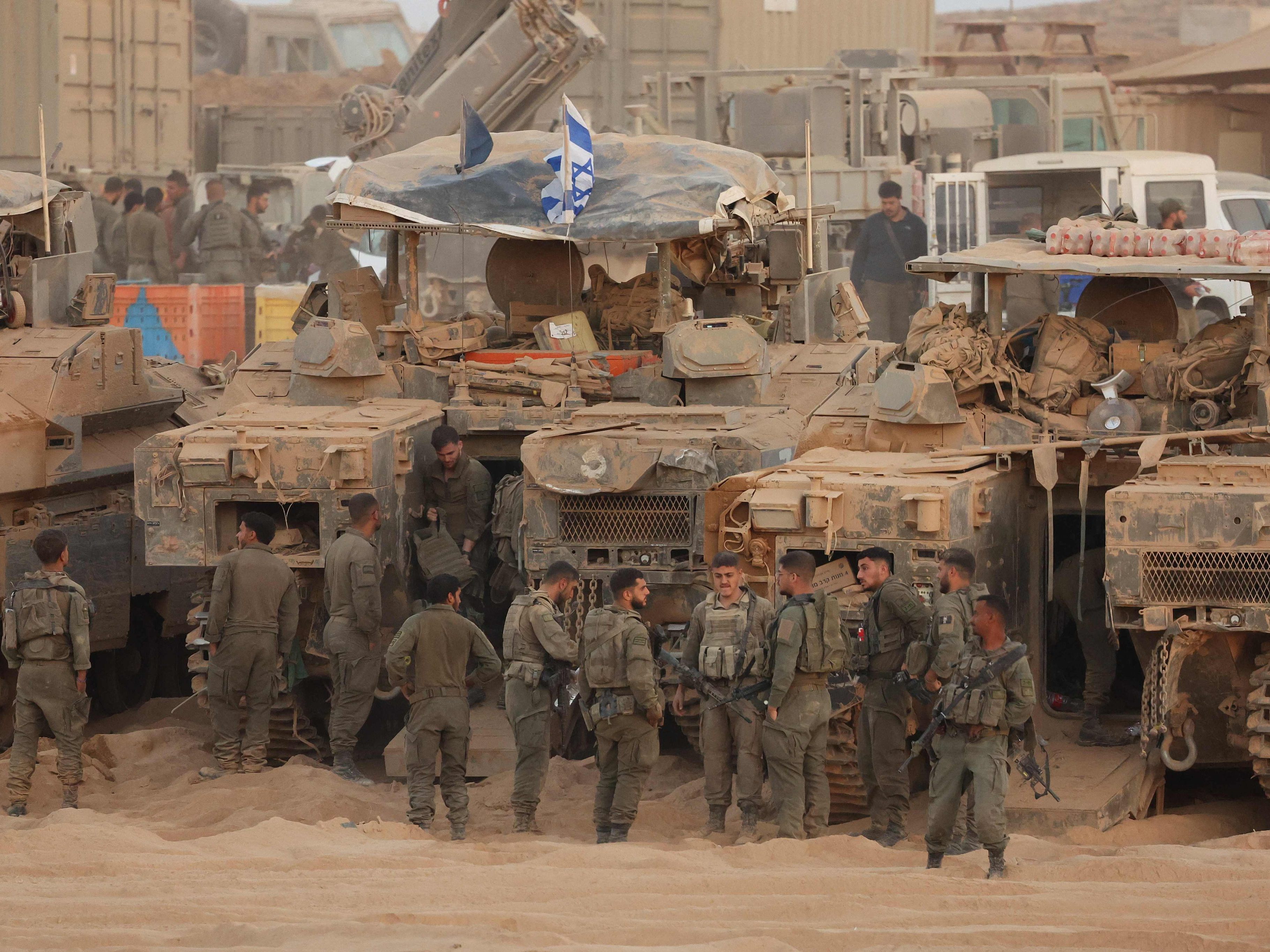 Israelische Soldaten versammeln sich am 10. Oktober 2025 in der Nähe gepanzerter Fahrzeuge an einer Position entlang des Grenzzauns zwischen Israel und dem Gazastreifen.