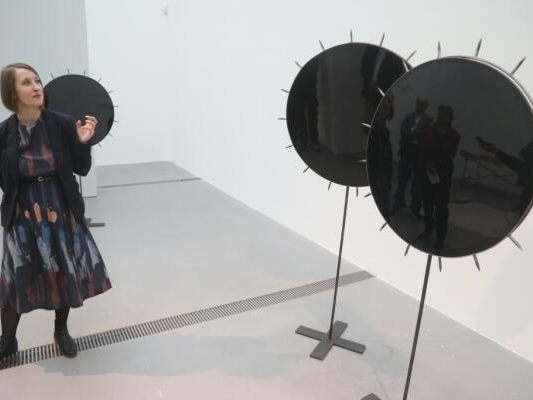 Co-Kuratorin Sarah Jonas betrachtet "Witnesses"-Sonnenblumen von Darja Kolzowa