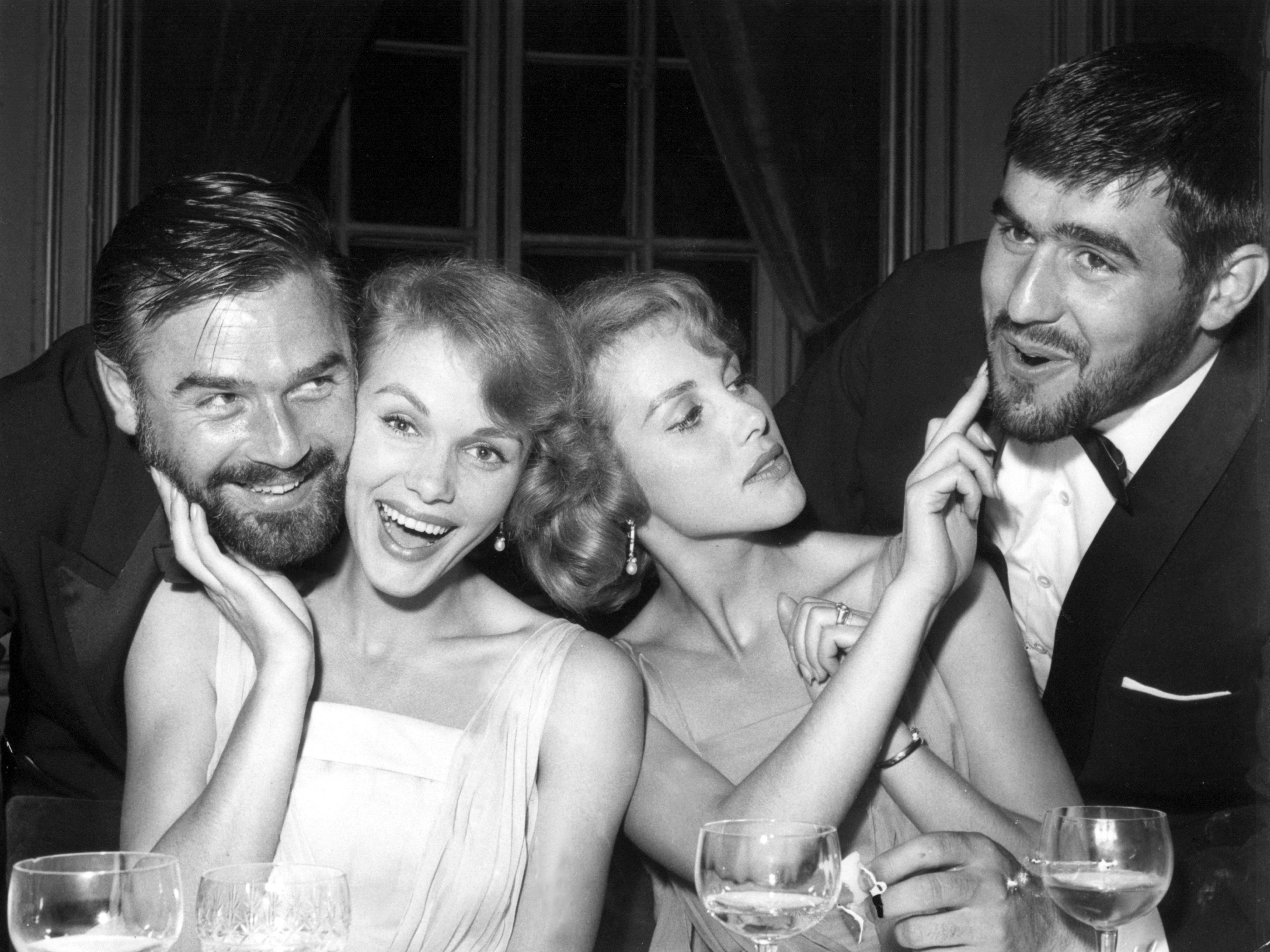 Verehrer immer zahlreich vorhanden: Alice und Ellen Kessler mit den Schauspielern Joachim Fuchsberger (l) und Mario Adorf bei einem Filmfest 1959 in Berlin.