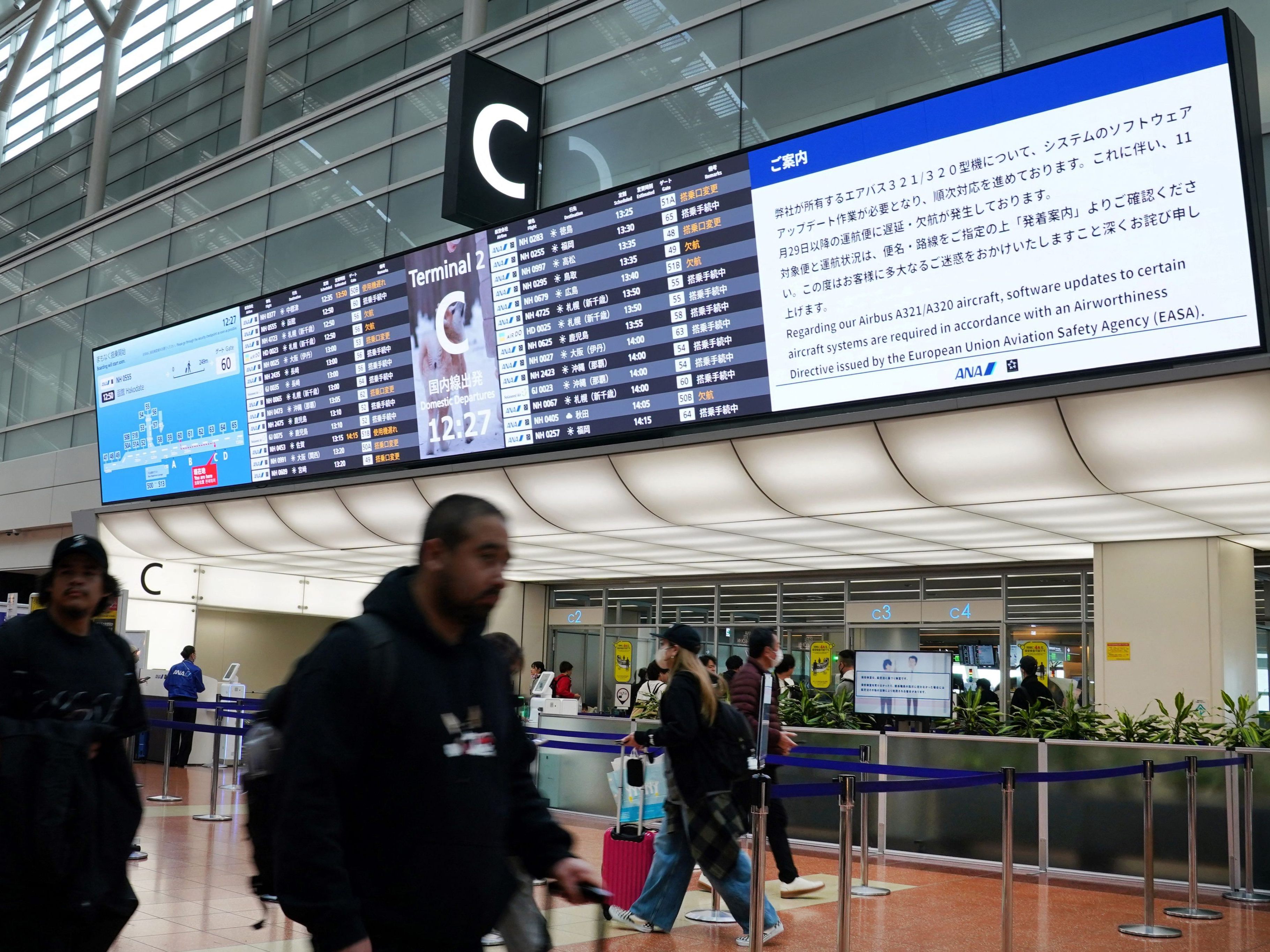 Fluglinien weltweit betroffen: Am Flughafen Haneda in Tokyo werden Passagiere über die Airbus-Software-Probleme informiert.