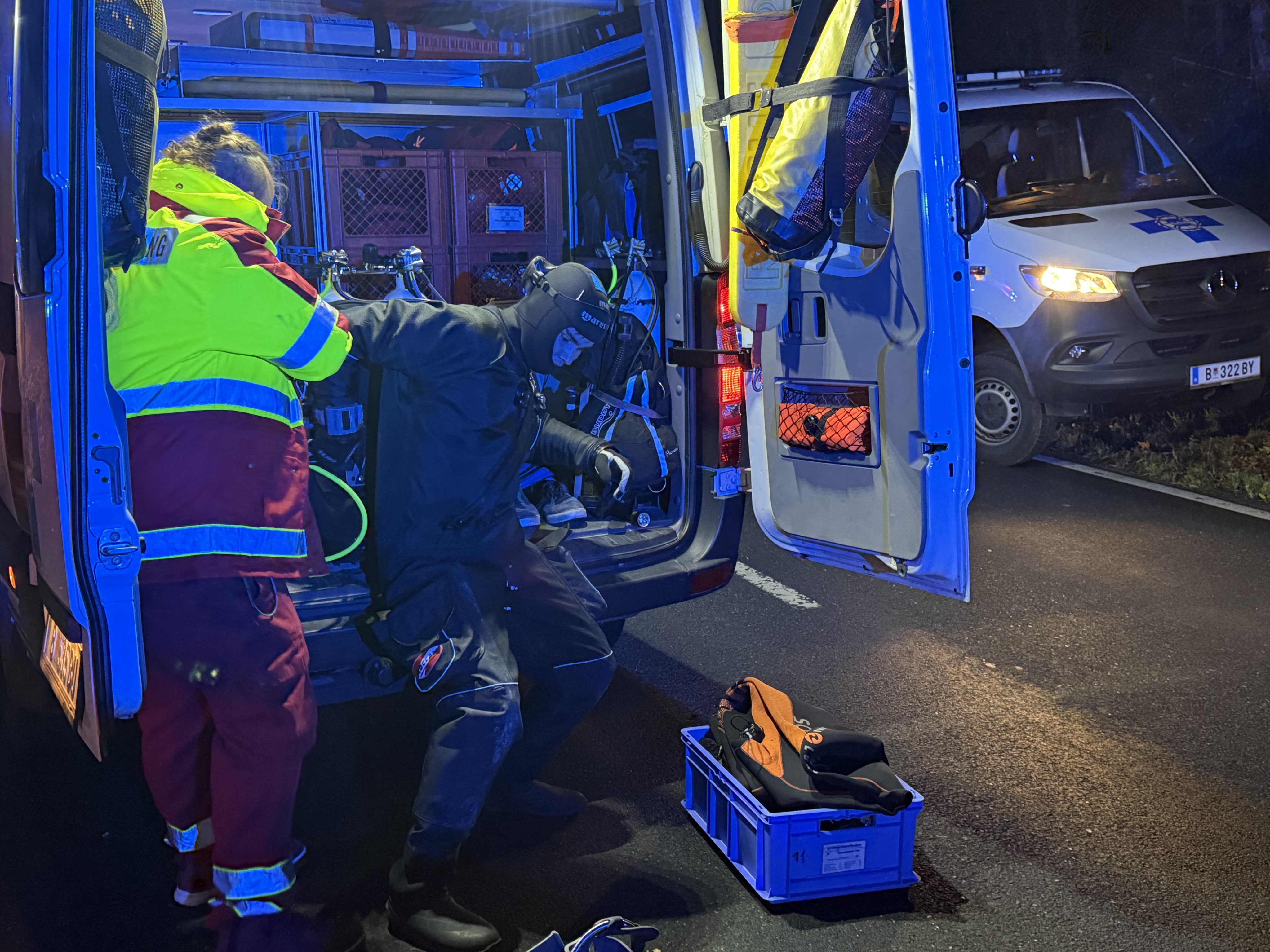 Ein Taucher der Wasserrettung rüstet sich im Einsatzfahrzeug für die Suche unter Wasser aus.