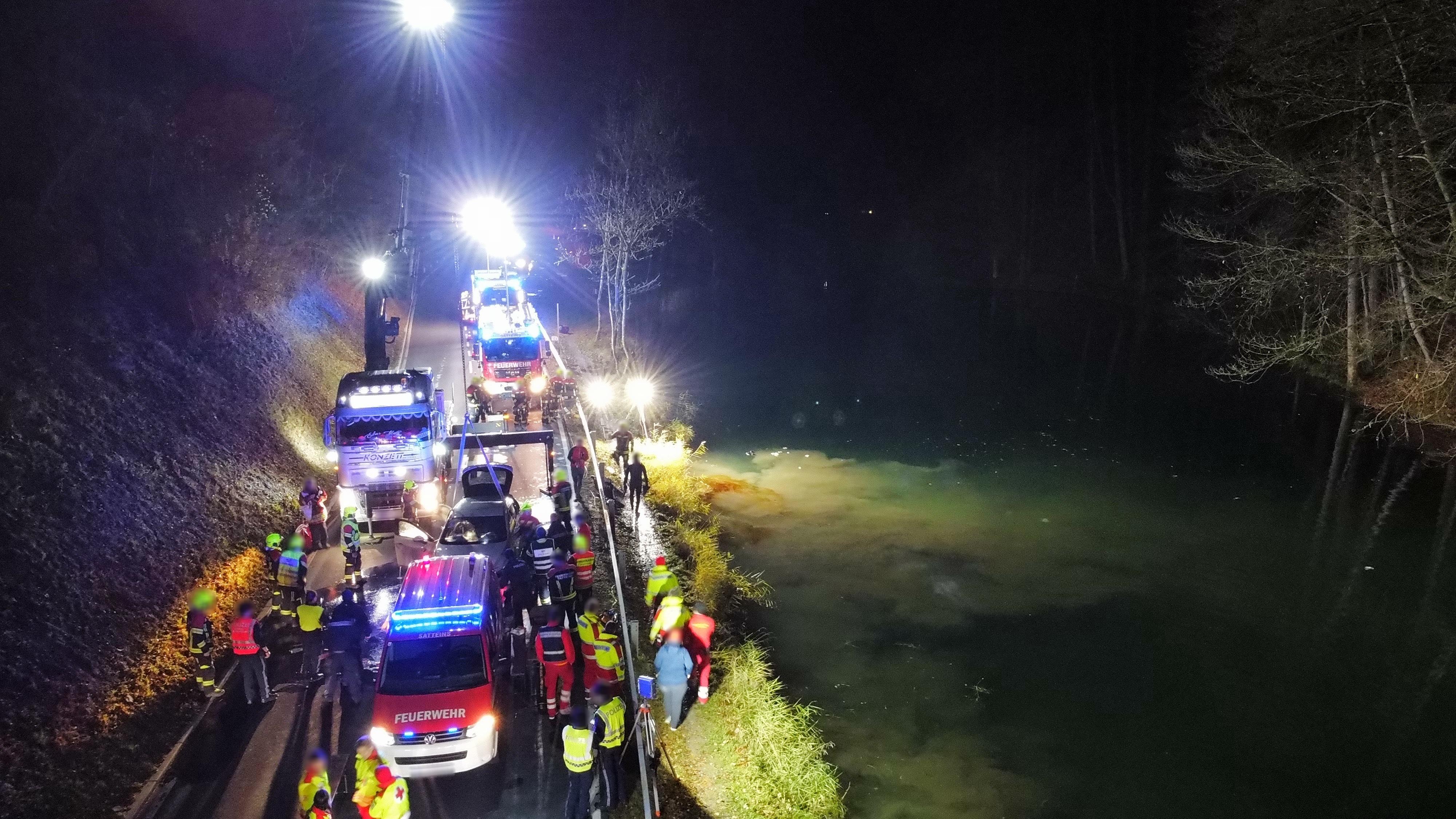 Wasserrettung und Polizei koordinieren den Einsatz – im Hintergrund wird der Pkw mit einem Kran geborgen.