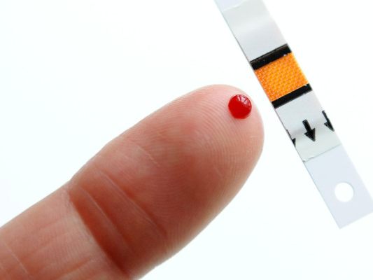 Patient macht eine Blutzuckermessung mit einem Teststreifen
