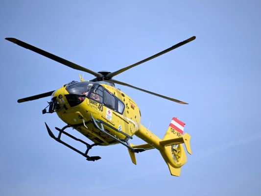 Auf dem Bild sieht man einen Notarzt-Hubschrauber vom ÖAMTC am Himmel fliegen.